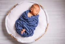 newborn baby enveloped blue scarf sleeps white pillow 8353 848